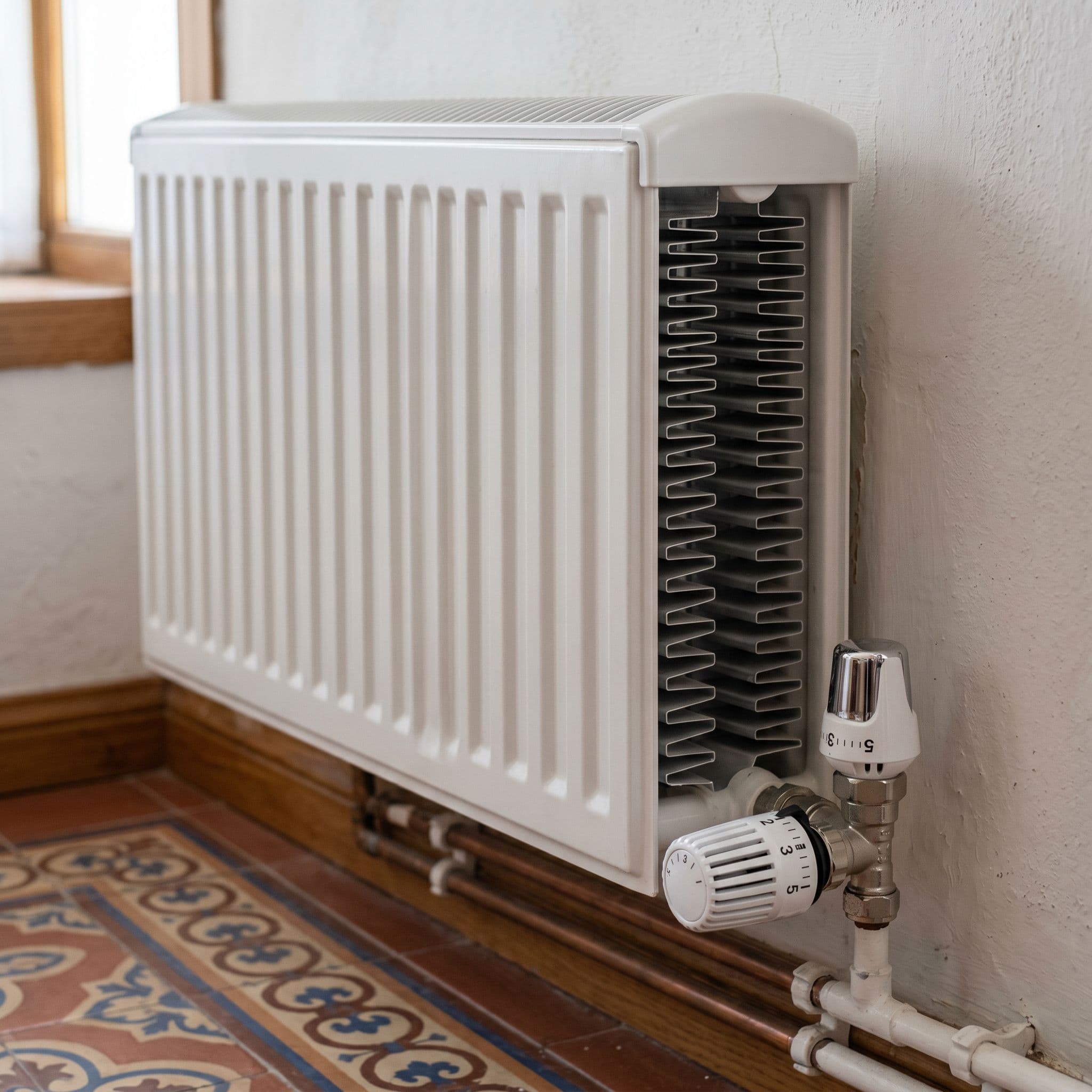 Radiador moderno de doble panel de acero con cabezal termostático.